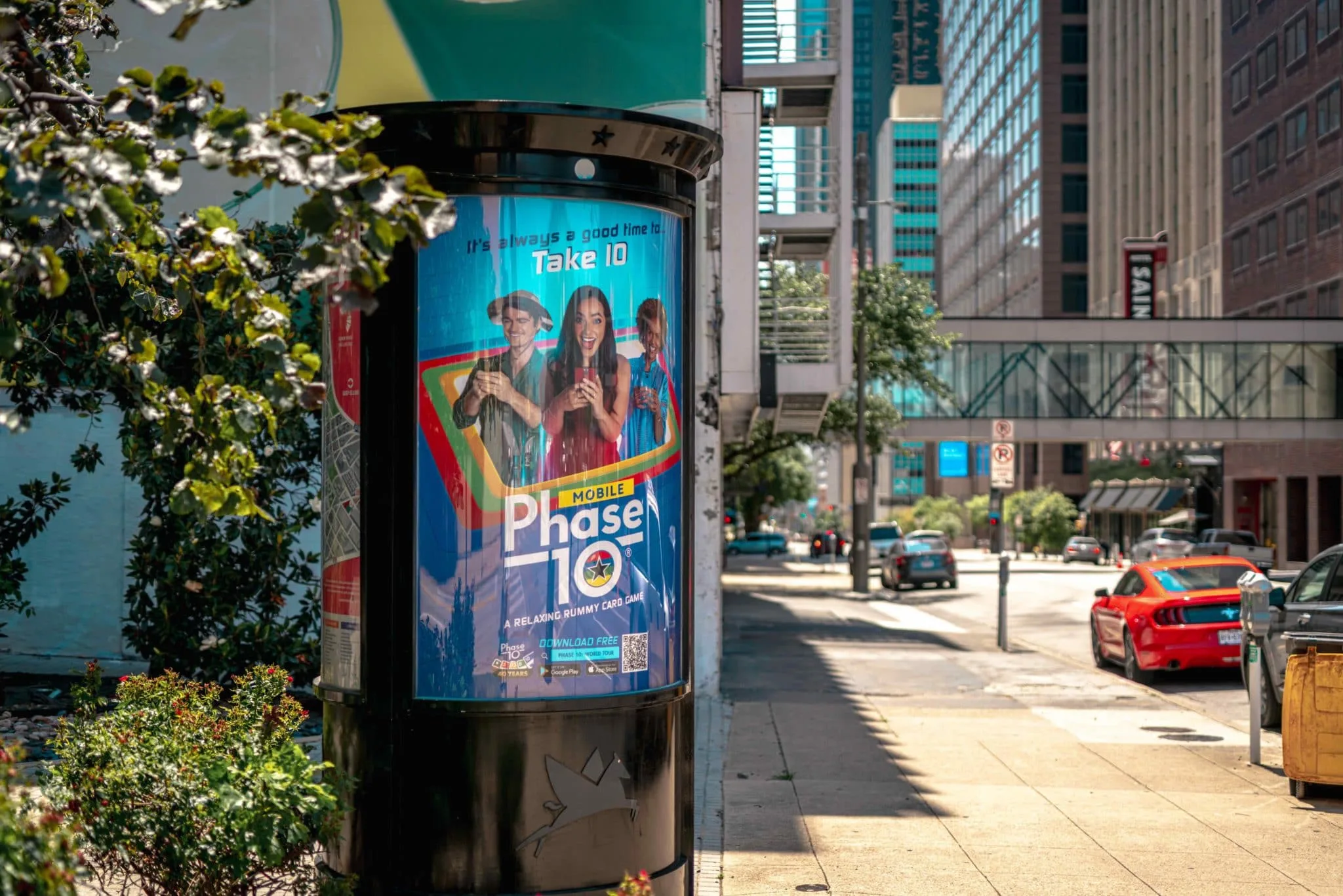 Phase 10 World Tour app advertisement on a downtown Dallas kiosk