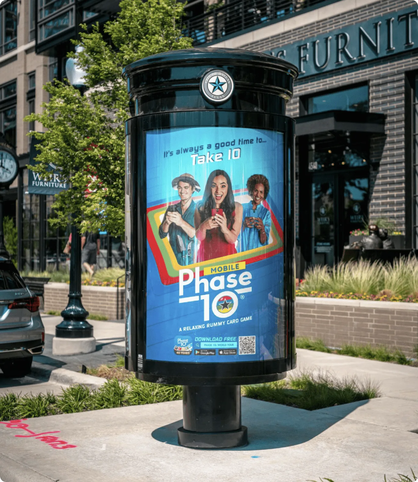 Phase 10 app campaign on a cylindrical kiosk in West Village Dallas