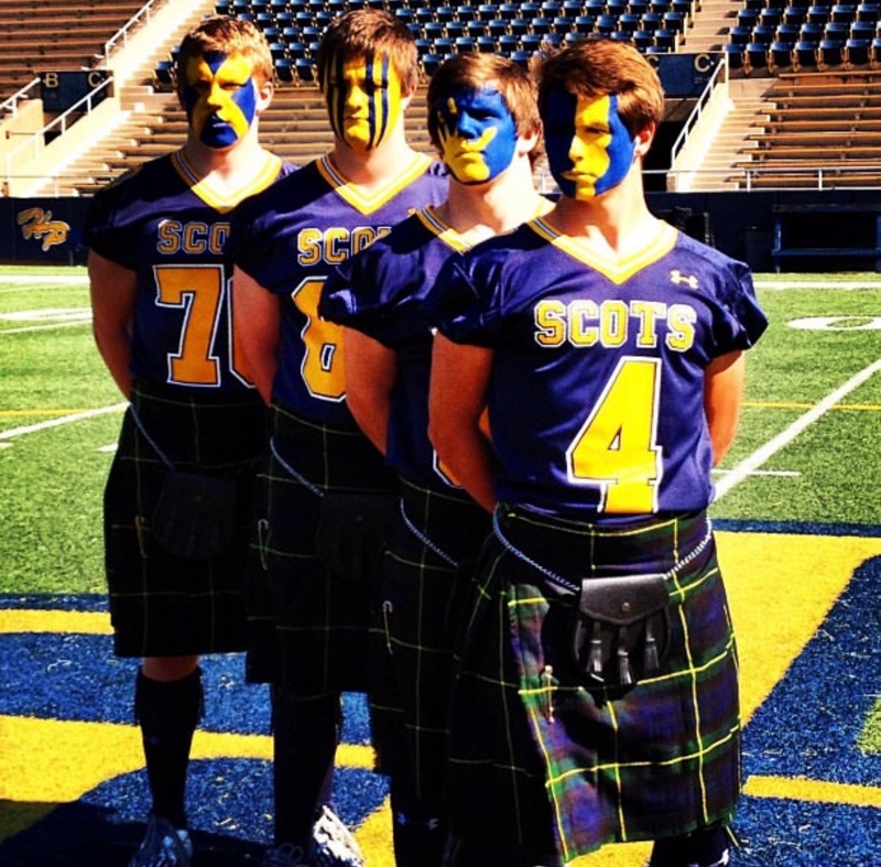 Cole Feigl, number 4, with Highland Park Scots football captains in kilts at Highlander Stadium