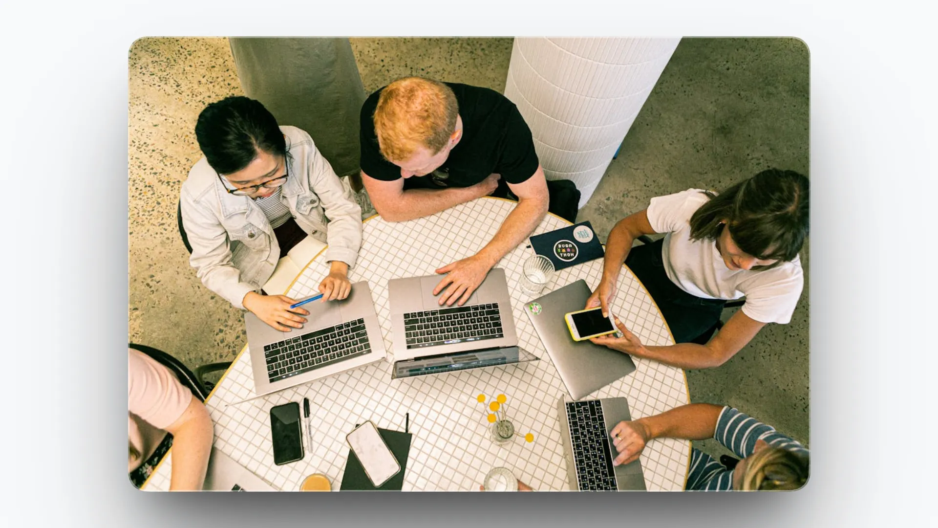 Marketing team collaborating around a table with laptops